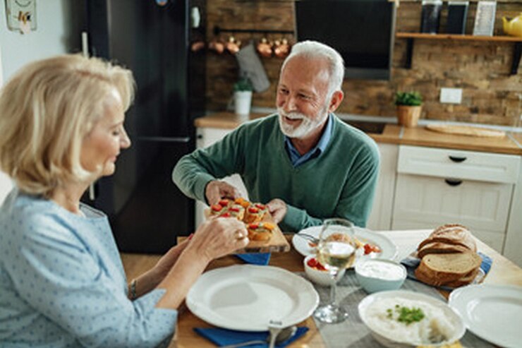 Photo un homme et une femme assis à une table avec de la nourriture et des boissons