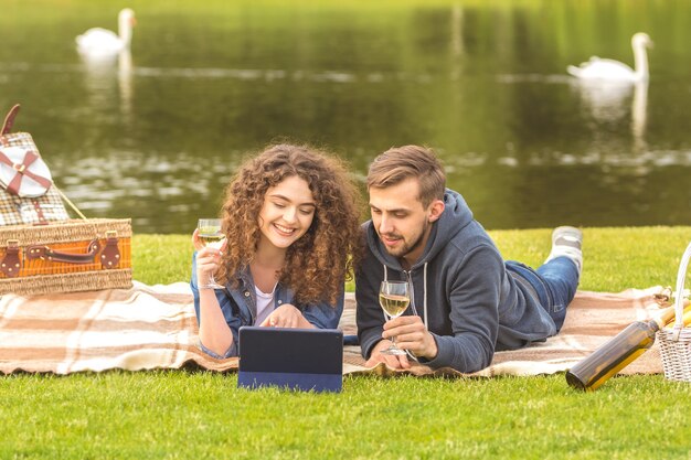 L'homme et la femme boivent un vin sur le rivage