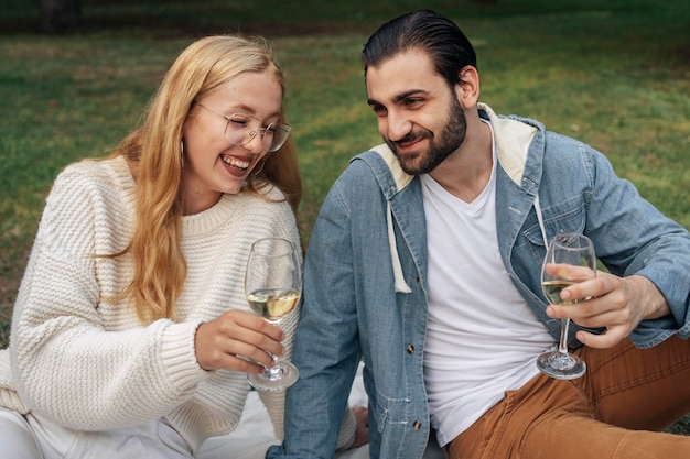 Homme et femme buvant du vin à l'extérieur