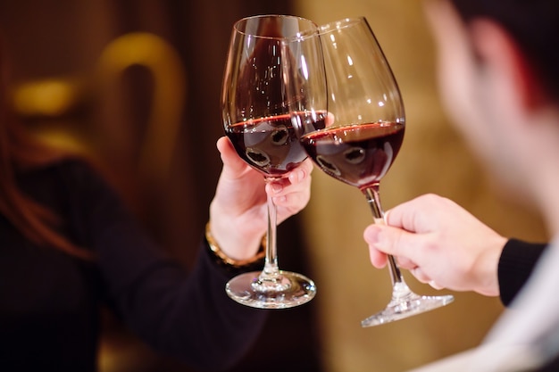 Un homme et une femme buvant du vin rouge.