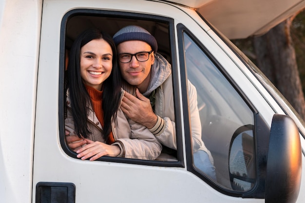 Homme et femme caucasiens embrassant en conduisant une voiture dans les bois. Concept de voyage et de route. Banque d'images