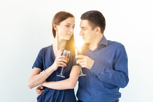 Homme et femme célébrant la fête de Noël ou du nouvel an avec des verres de champagne sur fond blanc.