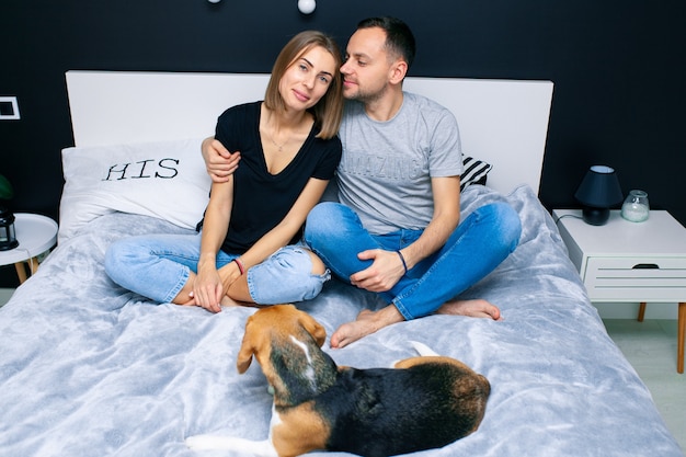 Homme et femme avec chien sur lit