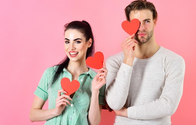 Homme et femme couple amoureux détiennent des cartes de Saint Valentin coeur rouge sur fond rose Couple romantique amoureux Concept de sentiments romantiques Saint Valentin et amour Bel homme et jolie fille amoureuse