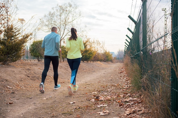 Photo un homme et une femme courent dans un parc