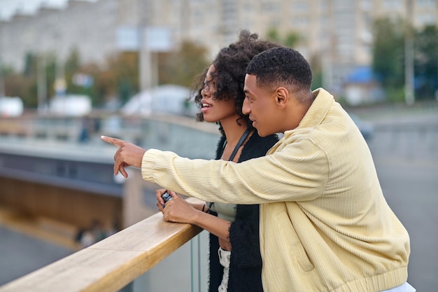 Homme et femme debout sur le côté de la caméra dans la rue