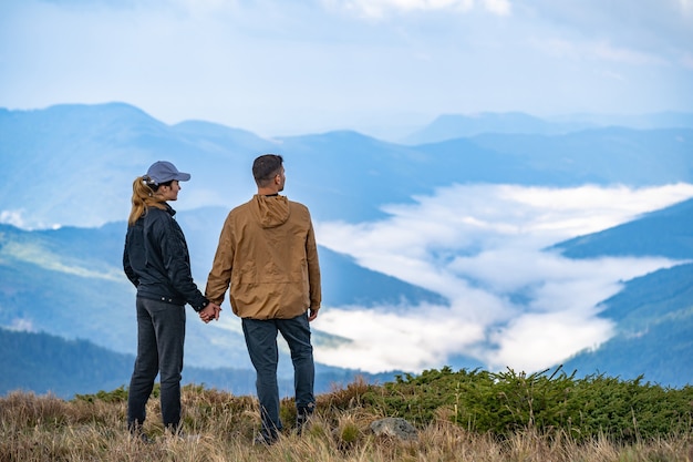 L'homme et une femme debout sur le fond du paysage de montagne