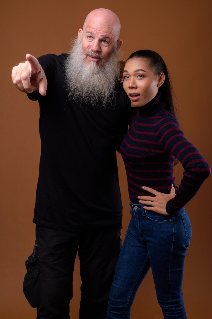 Photo un homme et une femme debout sur un fond gris.