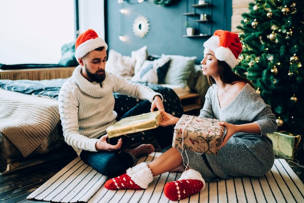 Homme et femme échangeant des cadeaux de Noël