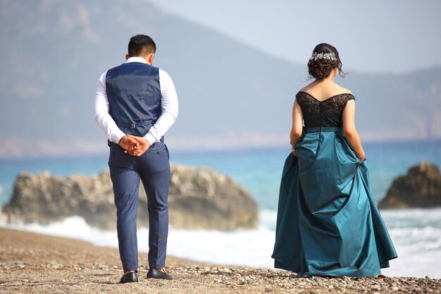 Homme et femme élégamment vêtus sur la plage