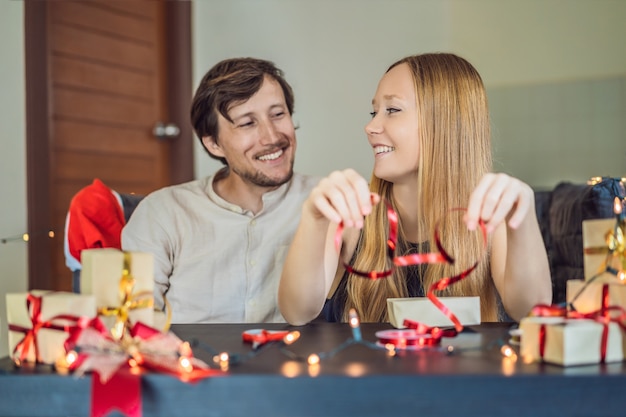 Homme et femme emballant des cadeaux