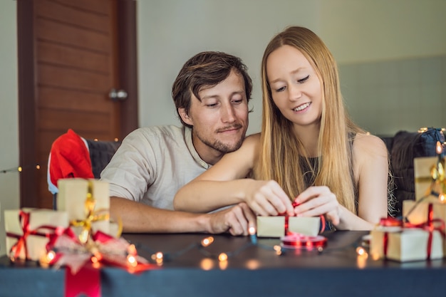 Homme et femme emballant des cadeaux