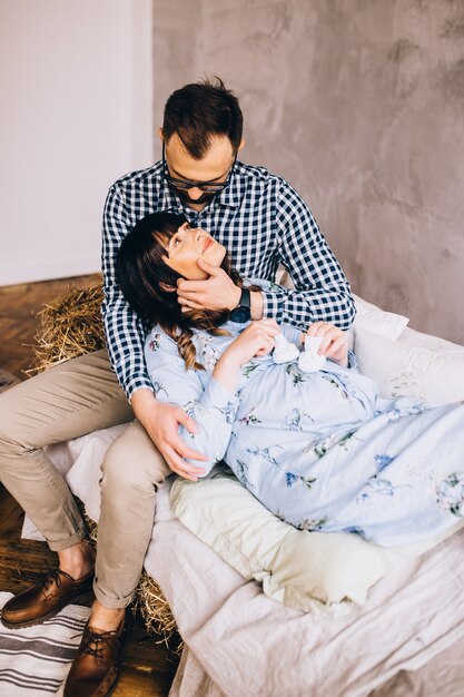 Un homme et une femme enceinte assise sur le canapé à la maison