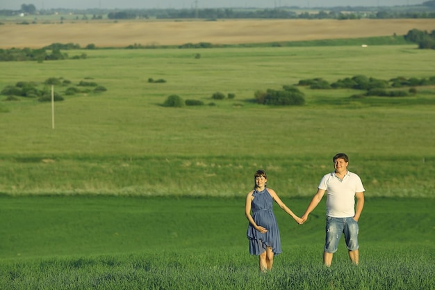 homme et une femme enceinte dans un champ d'été