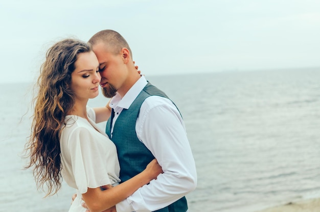 homme et femme étreignant au bord de la mer pendant leur lune de miel