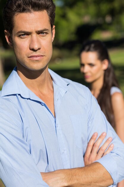 Homme avec une femme floue en arrière-plan en plein air