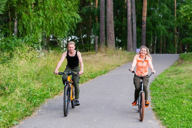 L'homme et la femme font du vélo à travers les bois