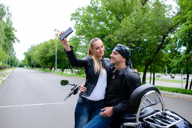 Homme et femme font un selfie sur une moto