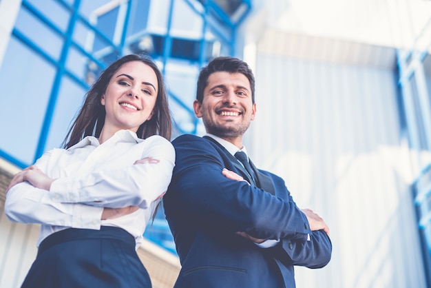 L'homme et la femme heureux se tiennent sur le fond du centre de bureau