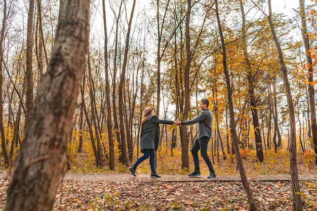 L'homme et la femme jouant dans le parc en automne