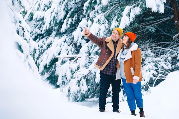 Homme et femme marchant sur un fond de forêt enneigée