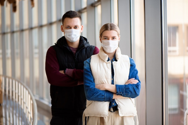 homme et femme avec masque médical à l'aéroport