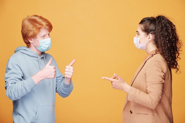 Homme et femme en masque médical parlant