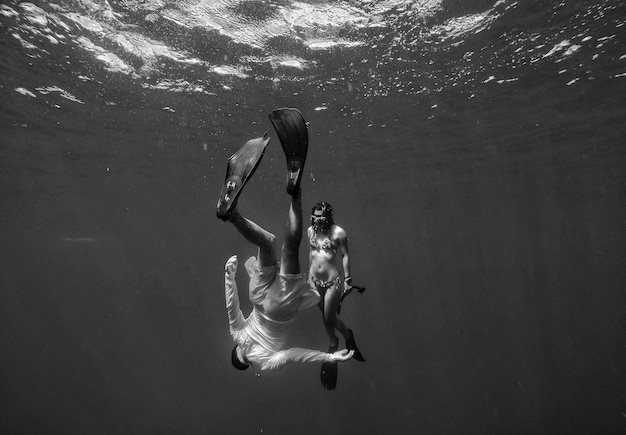 Photo un homme et une femme nageant dans la mer.