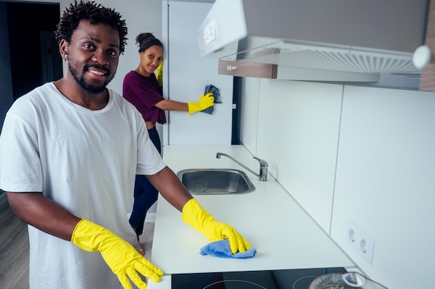Homme et femme nettoyant la cuisine à la maison