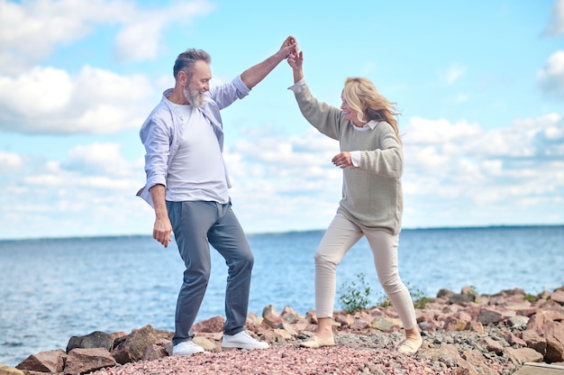 Homme et femme optimistes en promenade près de la mer