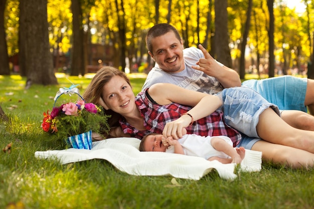 Homme et femme et petite fille nouveau-née dans le parc. Jeune famille heureuse.