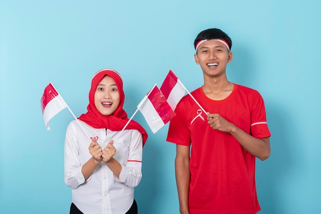 Homme et femme portant des attributs rouges et blancs complets ravis de célébrer le jour de l'indépendance de l'indonésie