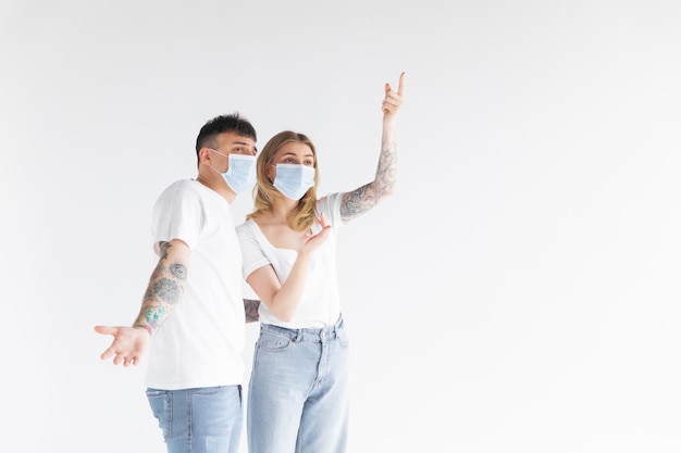 Homme et femme portant un masque facial se tenant l'un à l'autre en gardant une distance sociale en évitant