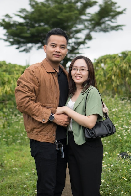 Un homme et une femme posent dans un champ de fleurs.