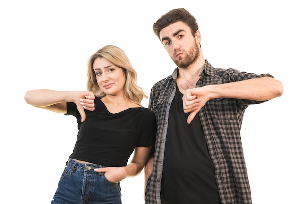 L'homme et la femme pouces vers le bas sur le fond blanc