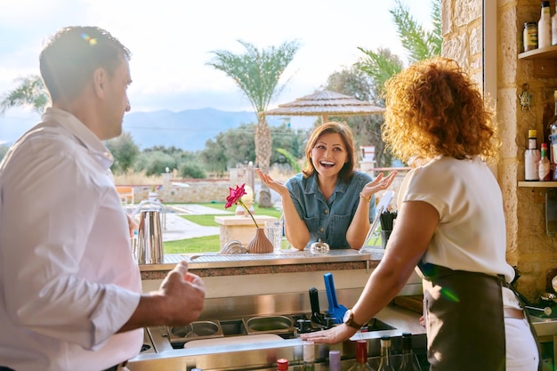 Homme et femme propriétaires d'entreprise travaillant au bar parlant au client