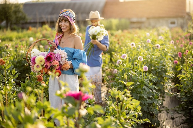 Un homme et une femme ramassent des fleurs à la ferme à l'extérieur