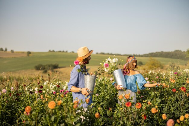 Un homme et une femme ramassent des fleurs à la ferme à l'extérieur