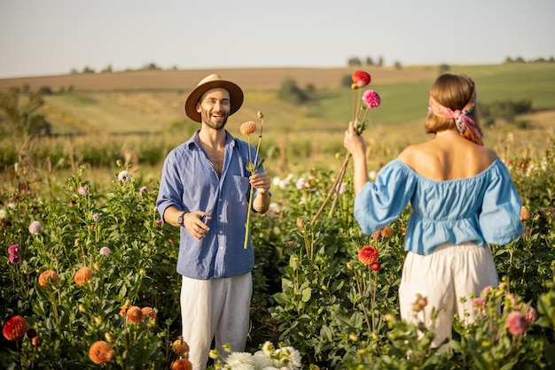 Un homme et une femme ramassent des fleurs à la ferme à l'extérieur