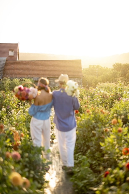 Un homme et une femme ramassent des fleurs à la ferme à l'extérieur