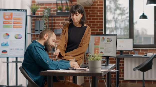 Un homme et une femme réfléchissent à des idées pour planifier un projet d'entreprise et concevoir des graphiques de taux sur ordinateur pour analyse. Collègues travaillant ensemble pour créer une présentation et une stratégie marketing