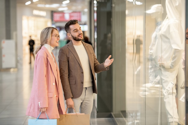 Un homme et une femme regardant un mannequin dans un présentoir dans un magasin