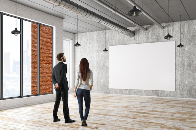 Homme et femme regardant un panneau d'affichage