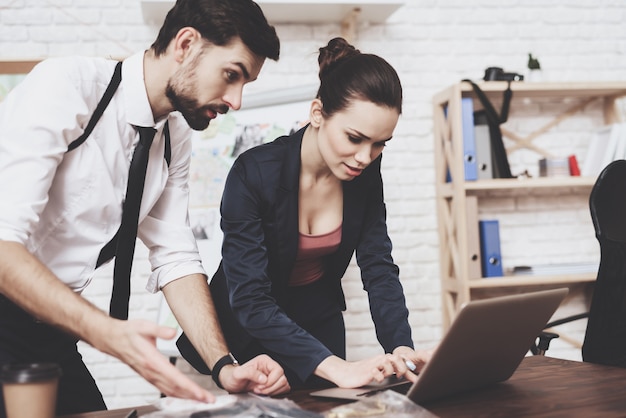 Un homme et une femme regardent des indices sur un ordinateur portable.