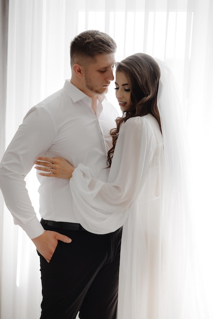 un homme et une femme s'embrassent et la femme porte une chemise blanche