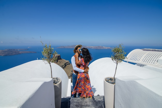 Un homme et une femme s'embrassent sur fond de Skaros Rock sur l'île de Santorin. Le village d'Imerovigli..Il est un gitan ethnique. Elle est israélienne.