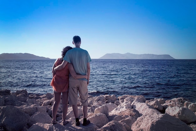 L'homme et la femme saluent le soleil sur la plage