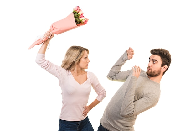 L'homme et une femme se battent avec des fleurs sur fond blanc