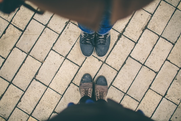 L'homme et la femme se font face. Gros plan des pieds en bottes d'hiver dans la rue
