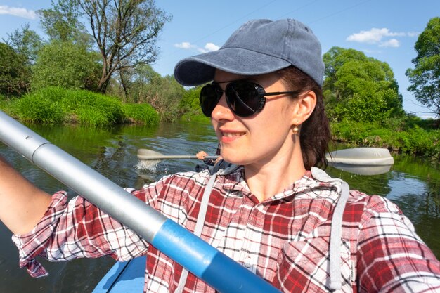 Un homme et une femme se font des selfies heureux en famille, en kayak, en bateau à rames sur la rivière, en randonnée sur l'eau, en aventure d'été, en tourisme écologique et extrême, en mode de vie actif et sain.